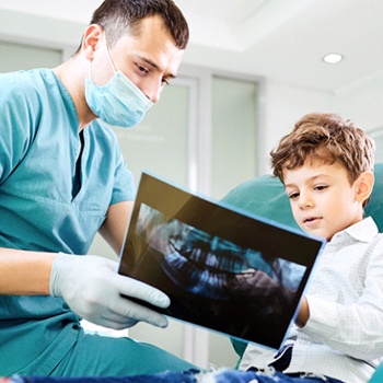 A dentist showing a young boy his dental X-Rays during an appointment