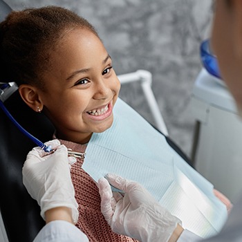 Child smiling at dentist after a tooth extraction in Duncanville