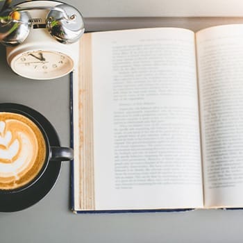 Coffee and an open book on a table